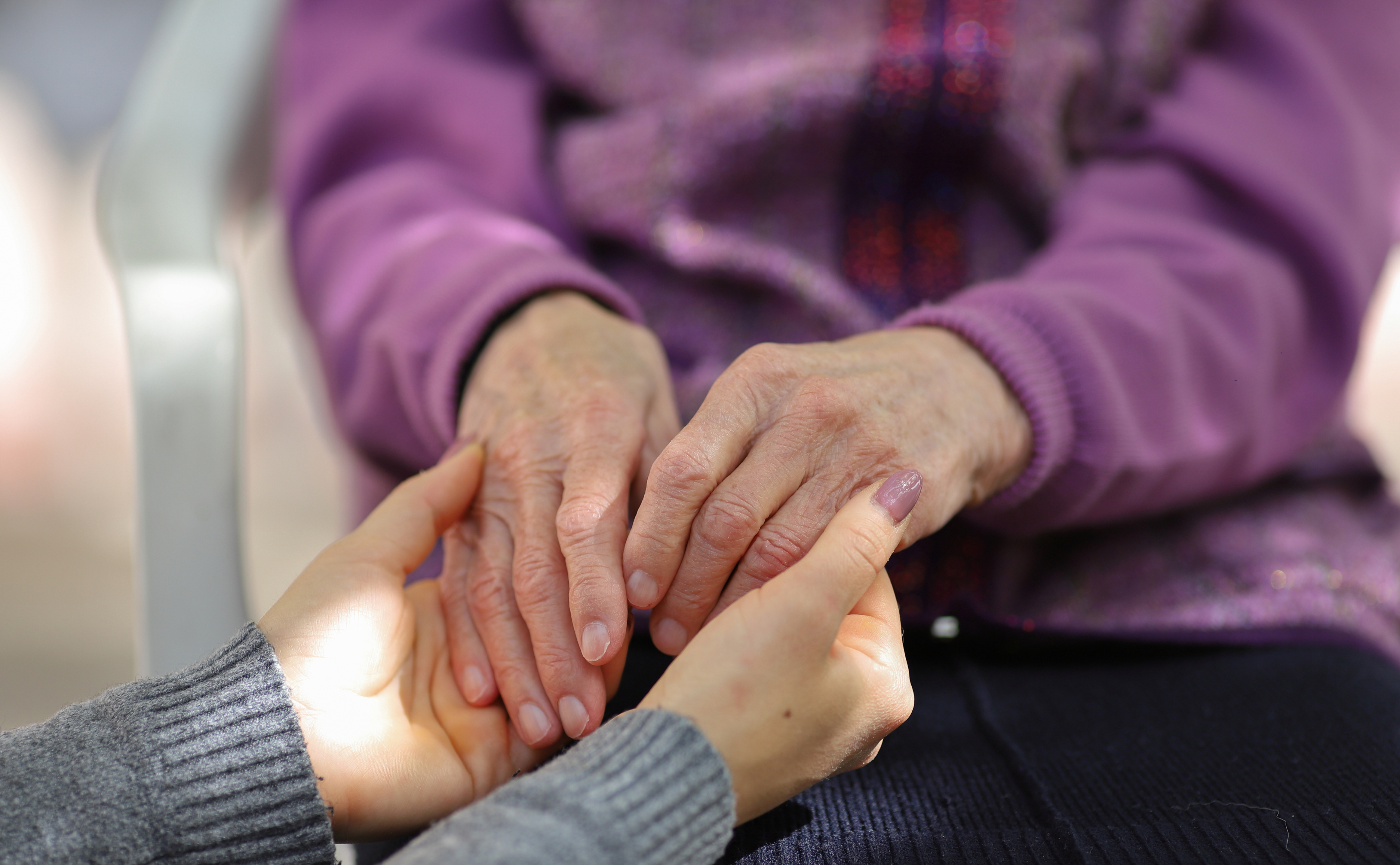 Caregiver and patient holding hands