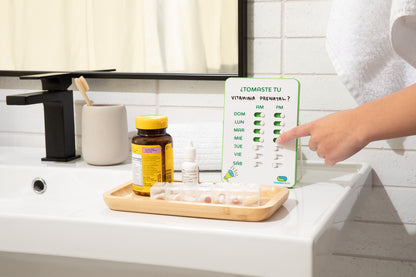 Person using a digital scale in a bathroom with a tray of supplements and a bottle of vitamins.