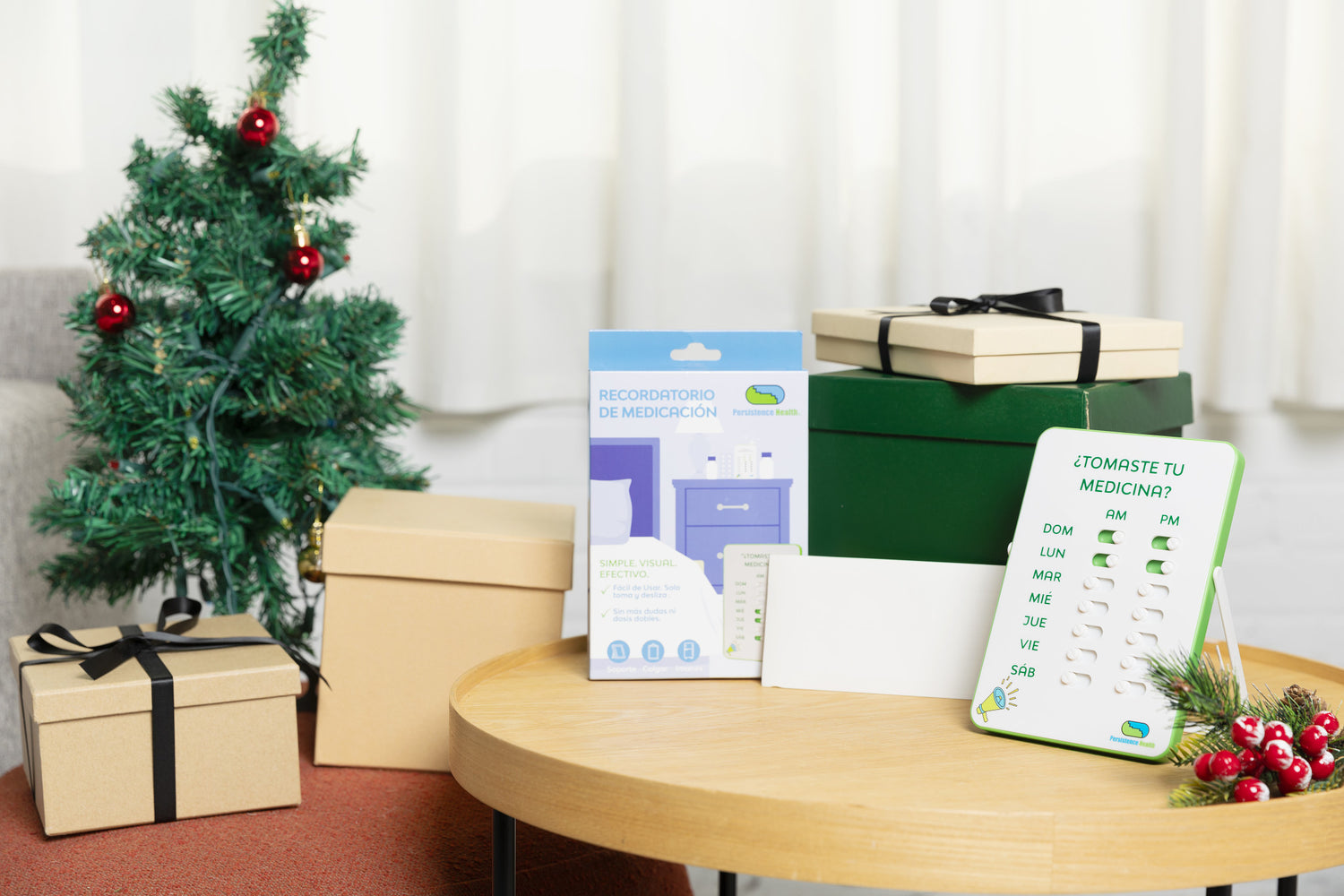 Christmas-themed room with a small tree, wrapped gifts, and a table with a product box and leaflet.